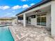 Beautiful outdoor patio with a covered area, pool views, and modern features, blending indoor-outdoor living seamlessly at 11828 Ranchers Gap Dr, Odessa, FL 33556