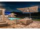 Stunning outdoor patio with ample seating, a pool with a water feature, and a scenic lake view under the night sky at 11828 Ranchers Gap Dr, Odessa, FL 33556