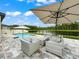 Relaxing outdoor patio with stylish furniture, a pool, and a picturesque lake view, perfect for entertaining and unwinding at 11828 Ranchers Gap Dr, Odessa, FL 33556