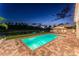 Inviting backyard pool at night, complete with outdoor seating and a peaceful lake view, illuminated for evening enjoyment at 11828 Ranchers Gap Dr, Odessa, FL 33556