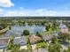 Stunning aerial view of homes by a tranquil lake featuring lush greenery and blue skies in a peaceful neighborhood at 12038 Steppingstone Blvd, Tampa, FL 33635