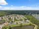 Wide aerial shot of a residential neighborhood with lush greenery, well-kept homes, and a peaceful lake at 12038 Steppingstone Blvd, Tampa, FL 33635