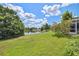 Expansive backyard overlooking a tranquil lake with mature trees and landscaping at 12038 Steppingstone Blvd, Tampa, FL 33635