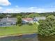 Aerial view of screened-in pools in backyards with a view of neighborhood lake and green lawn at 12038 Steppingstone Blvd, Tampa, FL 33635