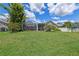 Wide-open backyard featuring a screened-in porch and flourishing landscaping at 12038 Steppingstone Blvd, Tampa, FL 33635