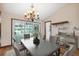 Dining room with modern chandelier, sliding glass doors with pool views, and convenient bar area for entertaining at 12038 Steppingstone Blvd, Tampa, FL 33635