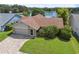 Charming single-story home with a brick driveway, attached garage, and lush landscaping overlooking the serene lake at 12038 Steppingstone Blvd, Tampa, FL 33635