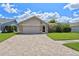 Charming single-story home featuring a brick-paved driveway, two-car garage, and well-manicured lawn at 12038 Steppingstone Blvd, Tampa, FL 33635