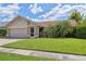 Inviting single-story home with lush landscaping, a screened-in porch, and a well-maintained lawn at 12038 Steppingstone Blvd, Tampa, FL 33635