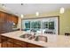 Kitchen island offers stone countertops, stainless steel sinks, and seamless access to the outdoor pool area at 12038 Steppingstone Blvd, Tampa, FL 33635