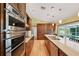 Gourmet kitchen featuring stainless steel appliances, granite countertops, a center island, and views of the outdoor pool at 12038 Steppingstone Blvd, Tampa, FL 33635