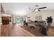 Spacious living room with hardwood floors, a ceiling fan, and sliding glass doors to the backyard pool at 12038 Steppingstone Blvd, Tampa, FL 33635