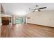 Spacious living room with hardwood floors, a ceiling fan, and sliding glass doors to the backyard pool at 12038 Steppingstone Blvd, Tampa, FL 33635