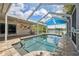 Screened in pool with brick decking and blue sun shade overlooking the lake at 12038 Steppingstone Blvd, Tampa, FL 33635