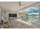 Covered and screened in pool with brick decking and view of the lake at 12038 Steppingstone Blvd, Tampa, FL 33635