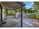 Spacious covered wooden back porch featuring wooden railings and a view of the backyard at 1217 E 29Th Ave, Tampa, FL 33605