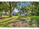 Spacious backyard surrounded by mature trees with a detached garage and an old-Florida style home at 1217 E 29Th Ave, Tampa, FL 33605