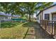 A view of the grassy backyard featuring a wooden deck and full perimeter fencing at 1217 E 29Th Ave, Tampa, FL 33605