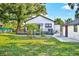 Well-maintained backyard with a wooden deck, mature trees, and detached garage at 1217 E 29Th Ave, Tampa, FL 33605