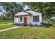Inviting bungalow with fresh exterior paint, mature trees, and a well-manicured lawn at 1217 E 29Th Ave, Tampa, FL 33605