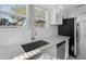 Bright kitchen features a stainless steel sink, modern appliances, white cabinetry, and stone countertops at 1217 E 29Th Ave, Tampa, FL 33605