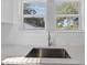 Close-up of the kitchen sink and stone countertops, showcasing the stainless steel faucet under a bright window at 1217 E 29Th Ave, Tampa, FL 33605