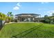 Screened-in lanai overlooks a large, manicured backyard with lush lawn and tropical landscaping at 12830 24Th Street E Cir, Parrish, FL 34219