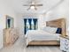Sunlit bedroom boasts wood furnishings, a ceiling fan, and a large window with relaxing backyard views at 12830 24Th Street E Cir, Parrish, FL 34219