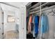 Closet with built-in shelving and hanging storage leading to a bathroom with double sinks at 12830 24Th Street E Cir, Parrish, FL 34219
