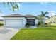 Beautiful single-story home featuring a well-maintained lawn, landscaping, and a two-car garage at 12830 24Th Street E Cir, Parrish, FL 34219