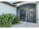 Enclosed front porch area with seating and decorative touches, surrounded by lush greenery at 12830 24Th Street E Cir, Parrish, FL 34219