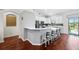 Modern kitchen boasts white cabinets, a breakfast bar, and sleek stainless steel appliances and hardwood floors at 12830 24Th Street E Cir, Parrish, FL 34219
