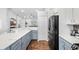 Open kitchen featuring stainless steel appliances, white countertops, and stylish blue-gray cabinetry at 12830 24Th Street E Cir, Parrish, FL 34219