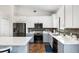 Contemporary kitchen showcasing stainless steel appliances, white cabinets, and a stylish tile backsplash at 12830 24Th Street E Cir, Parrish, FL 34219