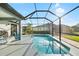 Beautiful screened-in pool surrounded by lush landscaping and sunny skies at 12830 24Th Street E Cir, Parrish, FL 34219