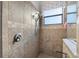 Tiled walk-in shower featuring modern fixtures and a window for natural light at 12830 24Th Street E Cir, Parrish, FL 34219