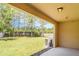 View of a grassy backyard with a treeline and fence as seen from the back patio at 12841 Buffalo Run Dr, Gibsonton, FL 33534