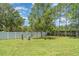 A large grassy backyard with a white fence bordering the property line at 12841 Buffalo Run Dr, Gibsonton, FL 33534