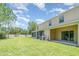 Large grassy backyard leads up to the rear of the home with a covered patio at 12841 Buffalo Run Dr, Gibsonton, FL 33534