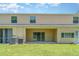Exterior view of the rear of the home with a covered patio and sliding glass doors at 12841 Buffalo Run Dr, Gibsonton, FL 33534
