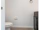 Bathroom featuring white toilet, dark wood cabinets, and bronze hardware at 12841 Buffalo Run Dr, Gibsonton, FL 33534