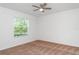 Bedroom featuring neutral walls, ceiling fan, carpeted floor and a view to the lush greenery outside at 12841 Buffalo Run Dr, Gibsonton, FL 33534