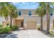 Exterior view of a townhouse with a garage, and landscaped front yard, with palm tree accents at 12841 Buffalo Run Dr, Gibsonton, FL 33534