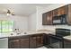 This updated kitchen features modern appliances, granite countertops, and dark wood cabinets at 12841 Buffalo Run Dr, Gibsonton, FL 33534
