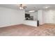 Open-concept living space with carpeting and a breakfast bar leading to the kitchen area at 12841 Buffalo Run Dr, Gibsonton, FL 33534