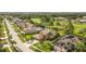 Overhead view of the home with palms, a golf course beyond, and tile roofs in the neighborhood at 13003 Carlington Ln, Riverview, FL 33579