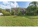 Backyard of home with a screened-in patio surrounded by mature trees, providing a serene and private outdoor space at 13003 Carlington Ln, Riverview, FL 33579