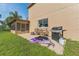 Home exterior with a screened-in porch and outdoor grill, perfect for enjoying outdoor cooking and relaxing in the backyard at 13003 Carlington Ln, Riverview, FL 33579