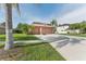 Home with a three-car garage, basketball hoop, and landscaping at 13003 Carlington Ln, Riverview, FL 33579