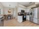 Kitchen features stainless steel appliances, white cabinets, granite countertops, and an adjacent dining area at 13003 Carlington Ln, Riverview, FL 33579